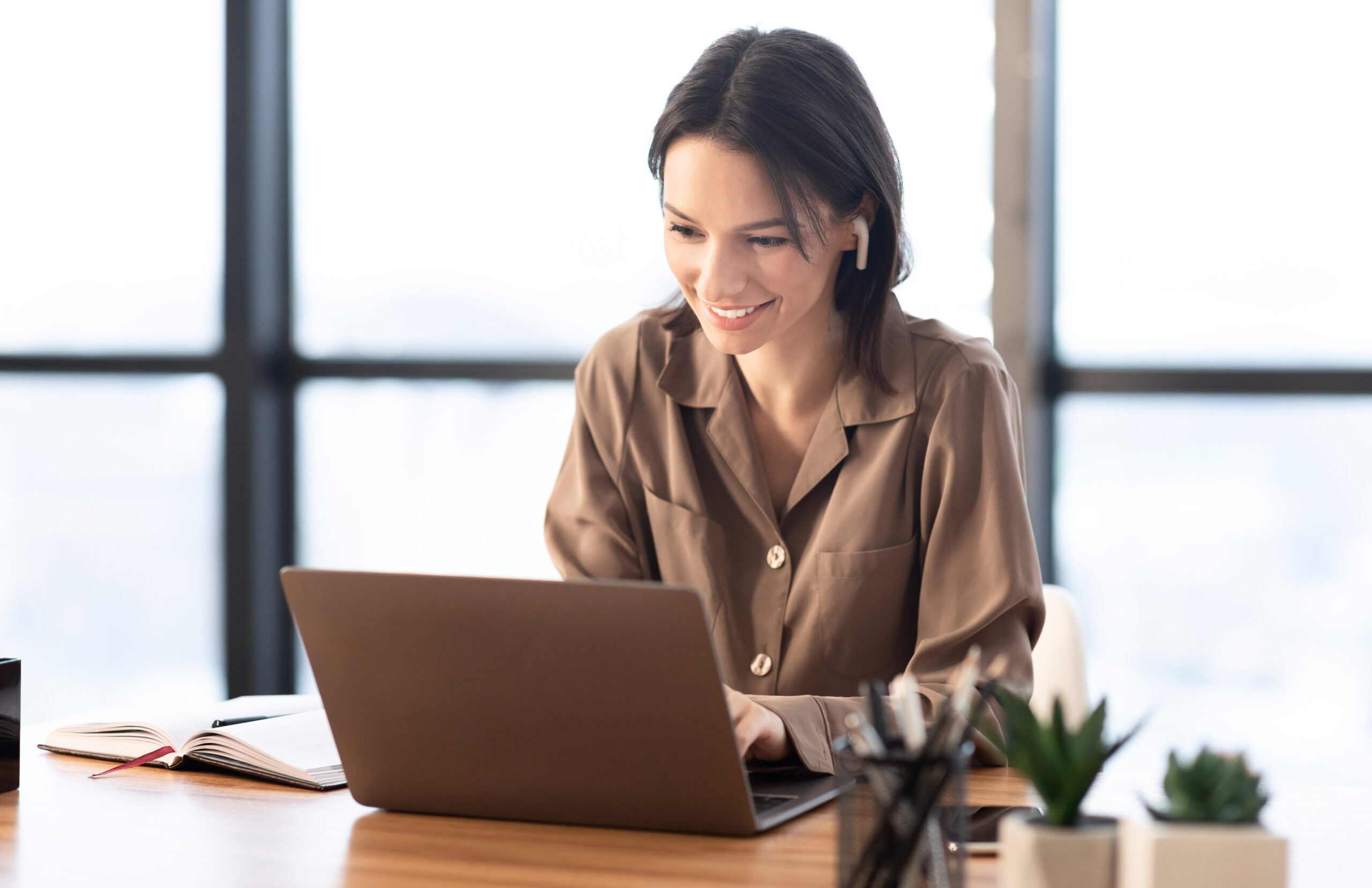 Portrait of happy woman listening to music using laptop